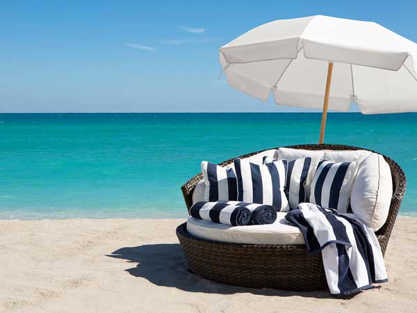 Big lounge chair and umbrella on the beach.