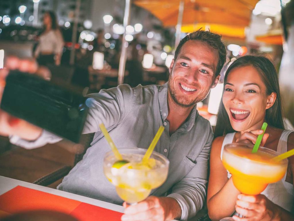 couple having cocktail taking selfy