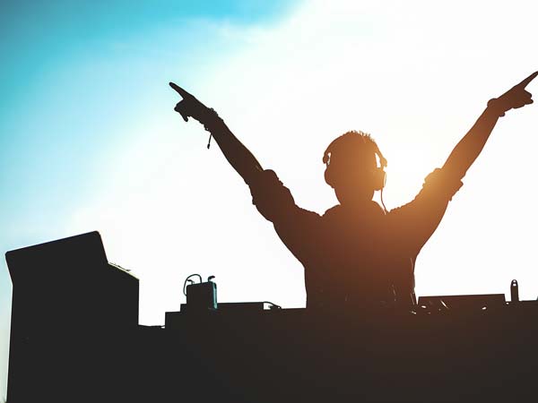 A DJ with his hands up in the air.