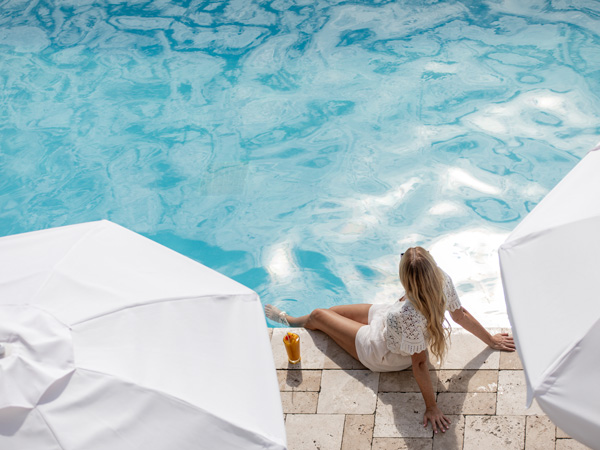 Lady Sitting By The Pool With A Drink