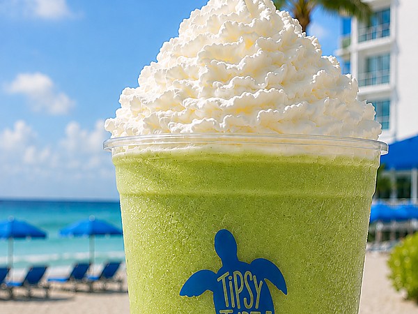 Tipsy Turtle frozen green cocktail topped with whipped cream at Sole Miami, A Noble House Resort in Sunny Isles Beach, with beachfront umbrellas and ocean views